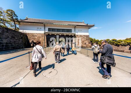 Tokyo, Japan - April 1, 2019: Park with people tourists entering entrance gate to Imperial palace on spring day in downtown by Kokyo Gaien Kokyogaien Stock Photo