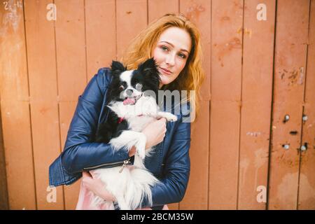 National pet's day. A young woman is holding a dog in her hands. Buying a dog. Happiness. To love animals. Veterinary Goods for pets. Animal clinic Stock Photo