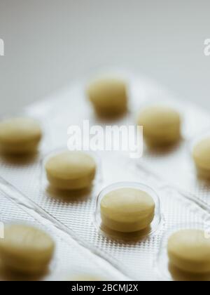 Blister with yellow pills closeup, side view. Stock Photo