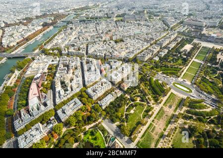 Overhead view from the Eiffel Tower platform of the city of Paris France with the Seine river, Champ de Mars park and Ecole Militaire in view.