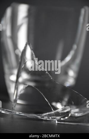 broken glass with pieces and fragments on dark black background, concept of danger Stock Photo