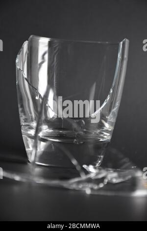 broken glass with pieces and fragments on dark black background, concept of danger Stock Photo