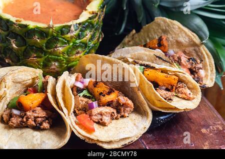 Tacos Al Pastor Shepherd's tacos, known as adobada tacos in the north of Mexico, spiced pork tacos with pineapple and spicy salsa Stock Photo