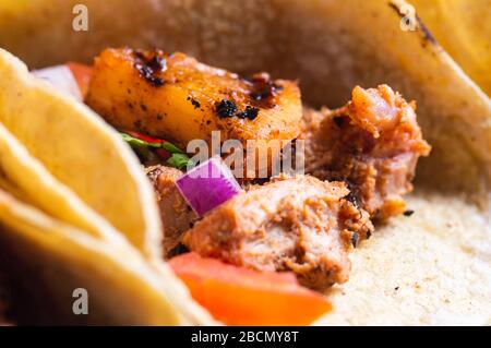 Tacos Al Pastor Shepherd's tacos, known as adobada tacos in the north of Mexico, spiced pork tacos with pineapple and spicy salsa Stock Photo