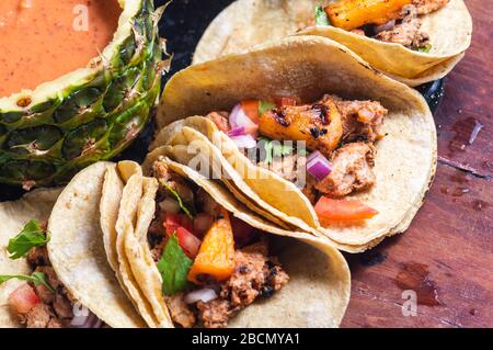 Tacos Al Pastor Shepherd's tacos, known as adobada tacos in the north of Mexico, spiced pork tacos with pineapple and spicy salsa Stock Photo