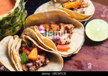 Tacos Al Pastor Shepherd's tacos, known as adobada tacos in the north of Mexico, spiced pork tacos with pineapple and spicy salsa Stock Photo