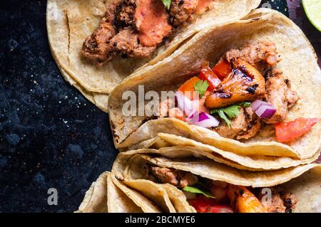 Tacos Al Pastor Shepherd's tacos, known as adobada tacos in the north of Mexico, spiced pork tacos with pineapple and spicy salsa Stock Photo
