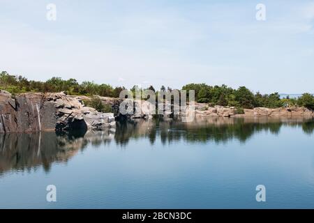 The former Babson Farm granite quarry filled with water at Halibut Point State Park in Rockport, Massachusetts, USA. Stock Photo