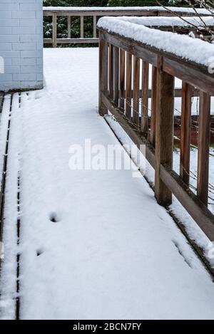 Fresh wet snow on a cedar deck, brick chimney Stock Photo