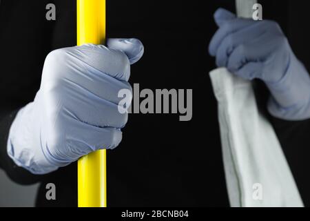 Hand in protective glove holding handlebar in public transport. Concept of personal protection means against virus, gems, covid-19 awareness concept Stock Photo