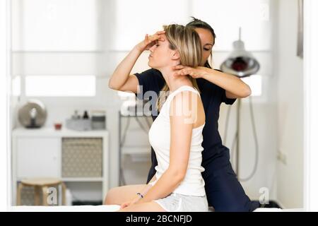 Physiotherapist inspecting her patient in a physiotherapy center. Stock Photo