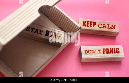 Stay home, keep calm and don't panic phrases on wooden blocks in the box and outside. Coronavirus prevention concept Stock Photo