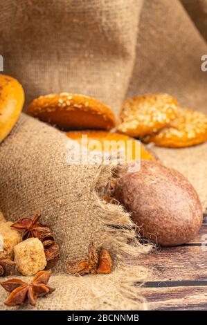 Bagels, chocolate cakes, cookies, star anise and chocolate on a background of coarse homespun fabric. Close up Stock Photo