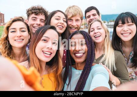Young friends from diverse cultures and races taking photo, making happy faces - Millennial generation and friendship concept with students people hav Stock Photo