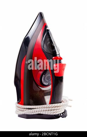 Simple new modern red iron, object isolated on white background, cut out, standing upright. Ironing, home use items, housework equipment, eu cable Stock Photo