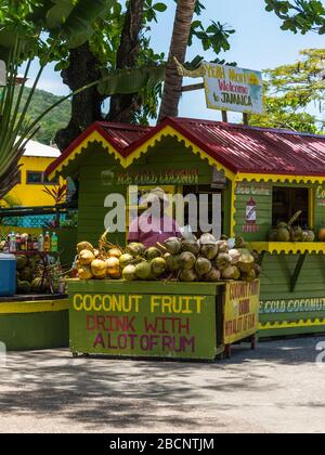 Ocho Rios, Jamaica - April 22, 2019: Ice Cold Coconut Fruit Drink with Rum stall/corner shop in rasta colors at the Ocho Rios Cruise Ship Port in the Stock Photo