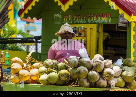 Ocho Rios, Jamaica - April 22, 2019: Ice Cold Coconut Fruit Drink with Rum stall/corner shop in rasta colors at the Ocho Rios Cruise Ship Port in the Stock Photo