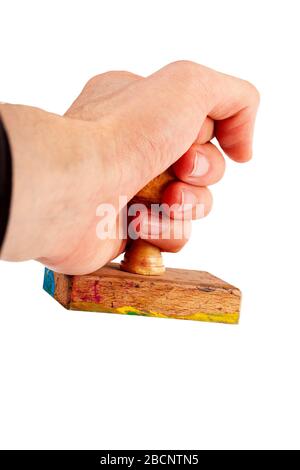 Wooden rubber stamp in hand, holding a simple traditional handstamp gesture isolated on white, cut out, closeup Accepting, agreement, confirmation Stock Photo
