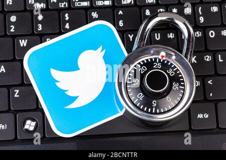 Twitter account password security simple abstract concept. Twitter service logo and a metal coded padlock, lock laying on a black laptop keyboard Stock Photo