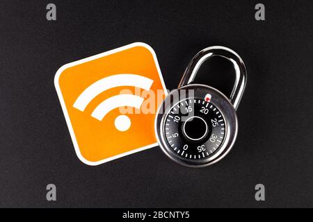 WiFi wireless network mobile security simple abstract concept. Wifi Connection signal symbol and a coded padlock laying on black background Stock Photo