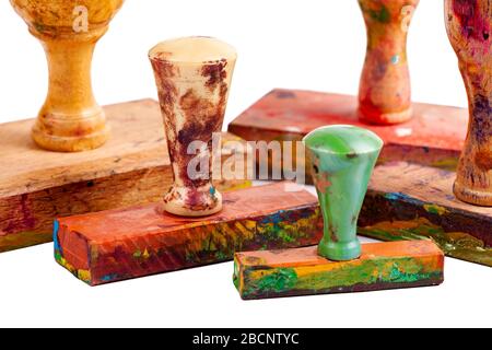 Few simple old artsy wooden hand stamps group, worn splashed, covered in paint, isolated, traditional classic rubber handstamps object closeup Stock Photo