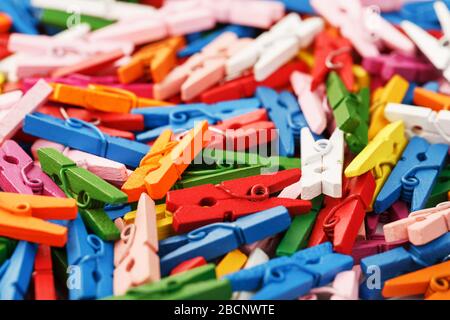 Multi-colored wooden clothespins as a full-screen texture and background. Decorative clothespins for creativity. The view from the top Stock Photo