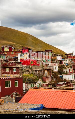 Shanty town of huts on a hillside at the Buddhist encampment at Yarchen Gar in the Tibetan part of Sichuan Province, China. Stock Photo