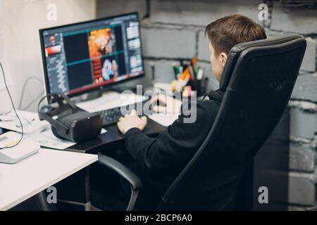 Stay home. Working home. Programmer with virtual reality headset, VR glasses with joystick with personal computer. Stock Photo
