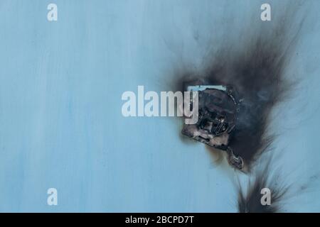 Apartment fire is caused by electrical outlet faults. Burnt and damaged electric plug socket from overload short circuit. Stock Photo