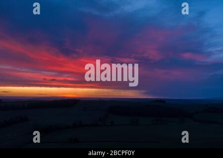 Dramatic colourful clouds over farming fields at dawn - aerial view. Shropshire Hills in United Kingdom Stock Photo