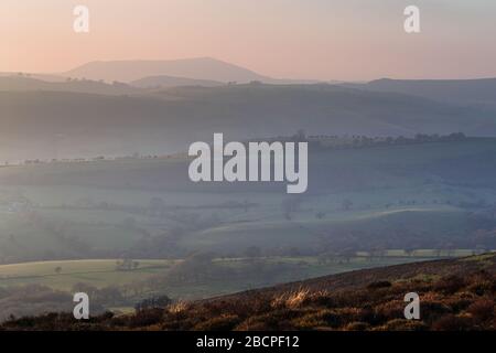 Rolling hills of british countryside at hazy sunset in Shropshire