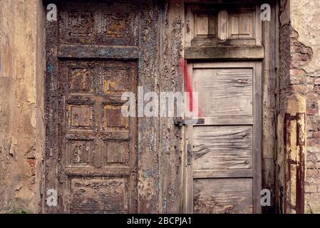 Old brocken grunge wooden doors with peeled paint with rusty lock Stock Photo