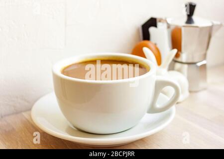 Coffee with milk cup, saucer, aluminum coffee maker, rabbit egg holder. Easter breakfast concept Stock Photo