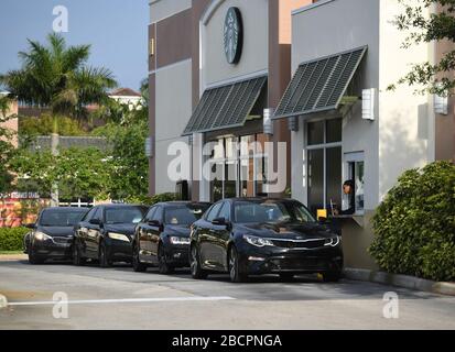 COCONUT CREEK, FL - APRIL 04: Customers are seen lining up at the Starbucks drive-thru as a stay-at-home order has been issued by Florida Governor Ron DeSantis due to the Coronavirus (COVID-19) pandemic on April 4, 2020 in Coconut Creek, Florida. Credit: mpi04/MediaPunch Stock Photo