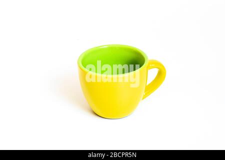 Little empty ceramic yellow and green coffee mug , coffee cup isolated on white background Stock Photo