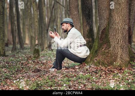 Man looking at flower, magnifier Stock Photo