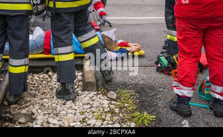 Emergency service personnel free an injured driver at the scene of a traffic accident during a training exercise. firefighters, paramedics Stock Photo