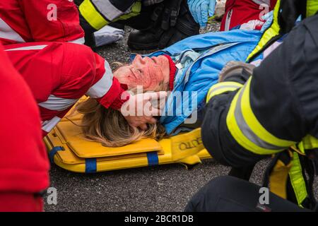 Emergency service personnel free an injured driver at the scene of a traffic accident during a training exercise.  firefighters, paramedics and Italia Stock Photo