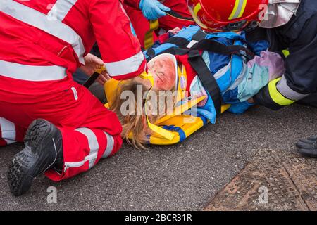 Emergency service personnel free an injured driver at the scene of a traffic accident during a training exercise.  firefighters, paramedics and Italia Stock Photo