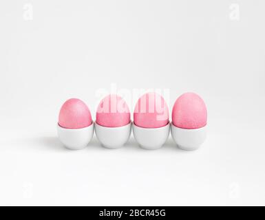 Easter composition with pink eggs in stands on a white background. Minimal Easter concept. Copy space. Stock Photo