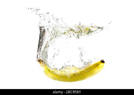 one banana falling into water on a white background with splashes. Stock Photo