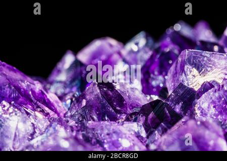 selective focus technique of healing amethyst purple crystal isolated on black Stock Photo