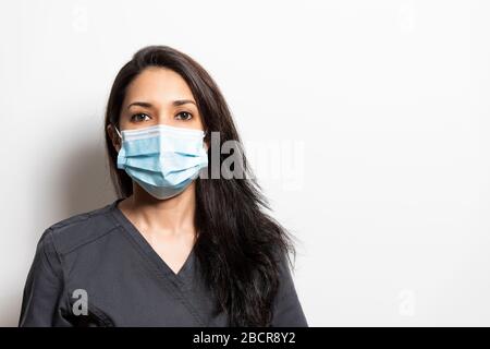 Portrait of a health professional wearing a mask. Dentist, doctor, nurse, assistant, isolated from white background. Stock Photo