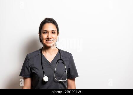 Portrait of a smiling doctor in a medical gown with a stethoscope on a white background Stock Photo