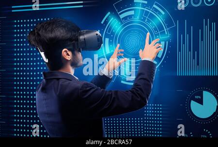 Businessman In Virtual Reality Headset Touching Digital Screen For Verification Stock Photo