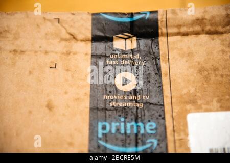 Lyon, France - Aug 7, 2019: Close-up macro shot wet Amazon Prime parcel cardboard with multiple water drops being delivered under rainy weather Stock Photo