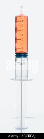 Medical Syringe with needle isolated on white, macro. Isolated syringe filled with red medication liquid. Fluid is like blood with bubbles. Stock Photo
