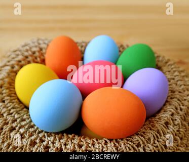 Closeup a Basket of Multi-color Easter Eggs on Wooden Table Stock Photo