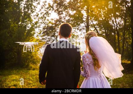Wedding couple pose for drone photo in autumn nature. Stock Photo