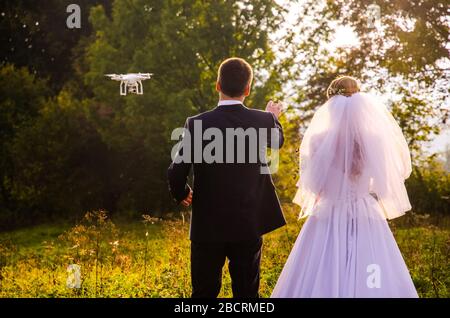 Wedding couple pose for drone photo in autumn nature. Stock Photo